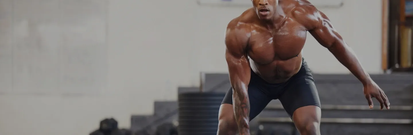 Muscular man sprinting outdoors, captured in a dramatic low-angle action shot.
